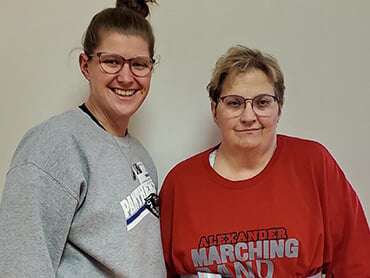 Elizabeth wearing a red t-shirt standing next to another woman.