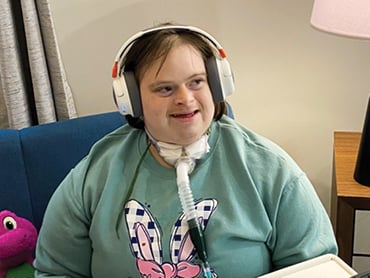 Louisa wearing her headphones and smiling.